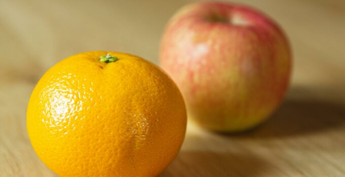 Ripe fresh tangerine with apple on table