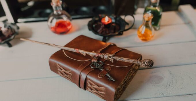 Brown Book and Wooden Stick on White Wooden Table