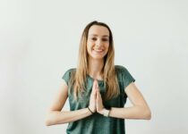 Fit smiling lady standing with Prayer hands while practicing yoga