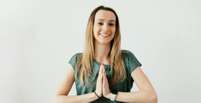 Fit smiling lady standing with Prayer hands while practicing yoga