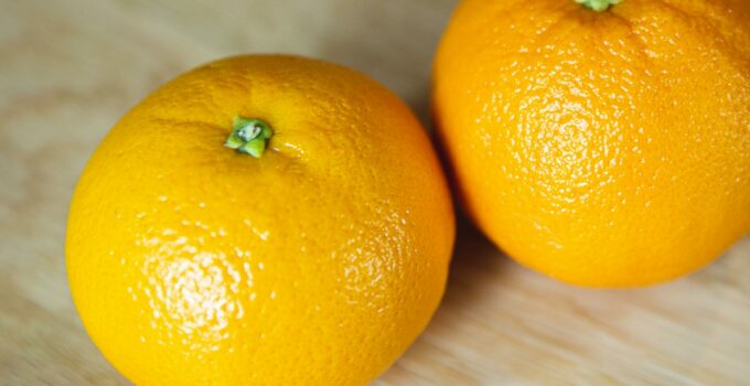 Bright whole ripe oranges on wooden table