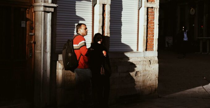 A man and a woman are standing outside of a building