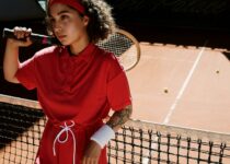 Woman in Red Shirt Leaning on Tennis Net