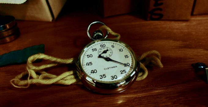 White Pocket Watch With Gold-colored Frame on Brown Wooden Board