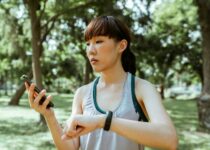 Concentrated young Asian woman using smartphone in park