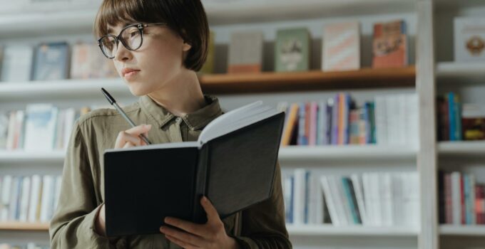 Woman in Green Jacket Reading Book