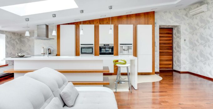 A modern kitchen with white cabinets and wooden floors