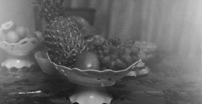 A black and white photograph of fruit in a bowl