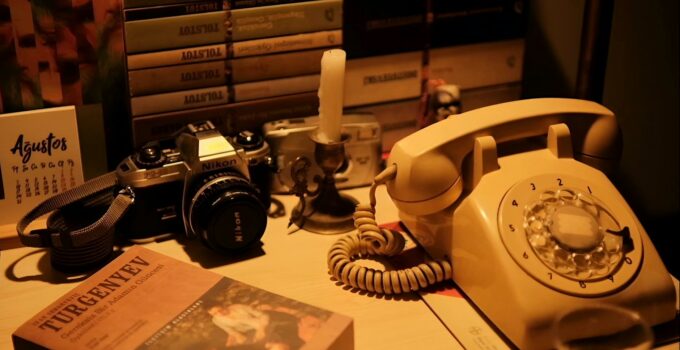 A desk with a telephone, books and a camera