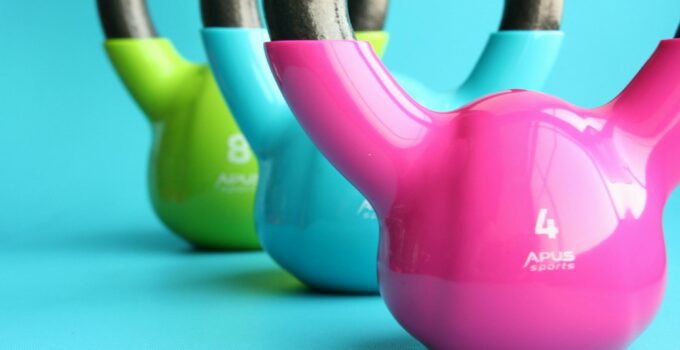 Green, Blue, and Pink Kettle Bells on Blue Surface