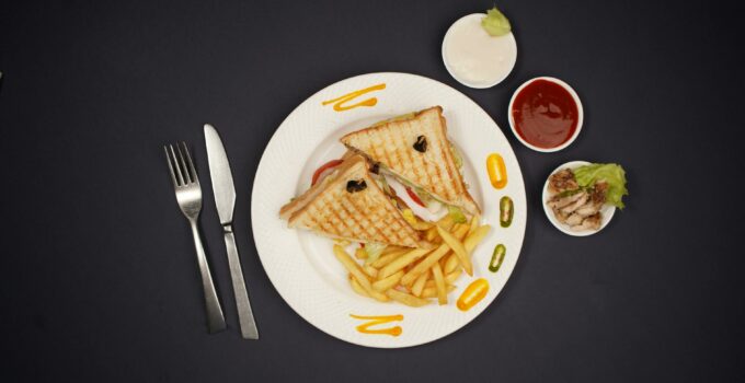 A plate with a sandwich and fries on it